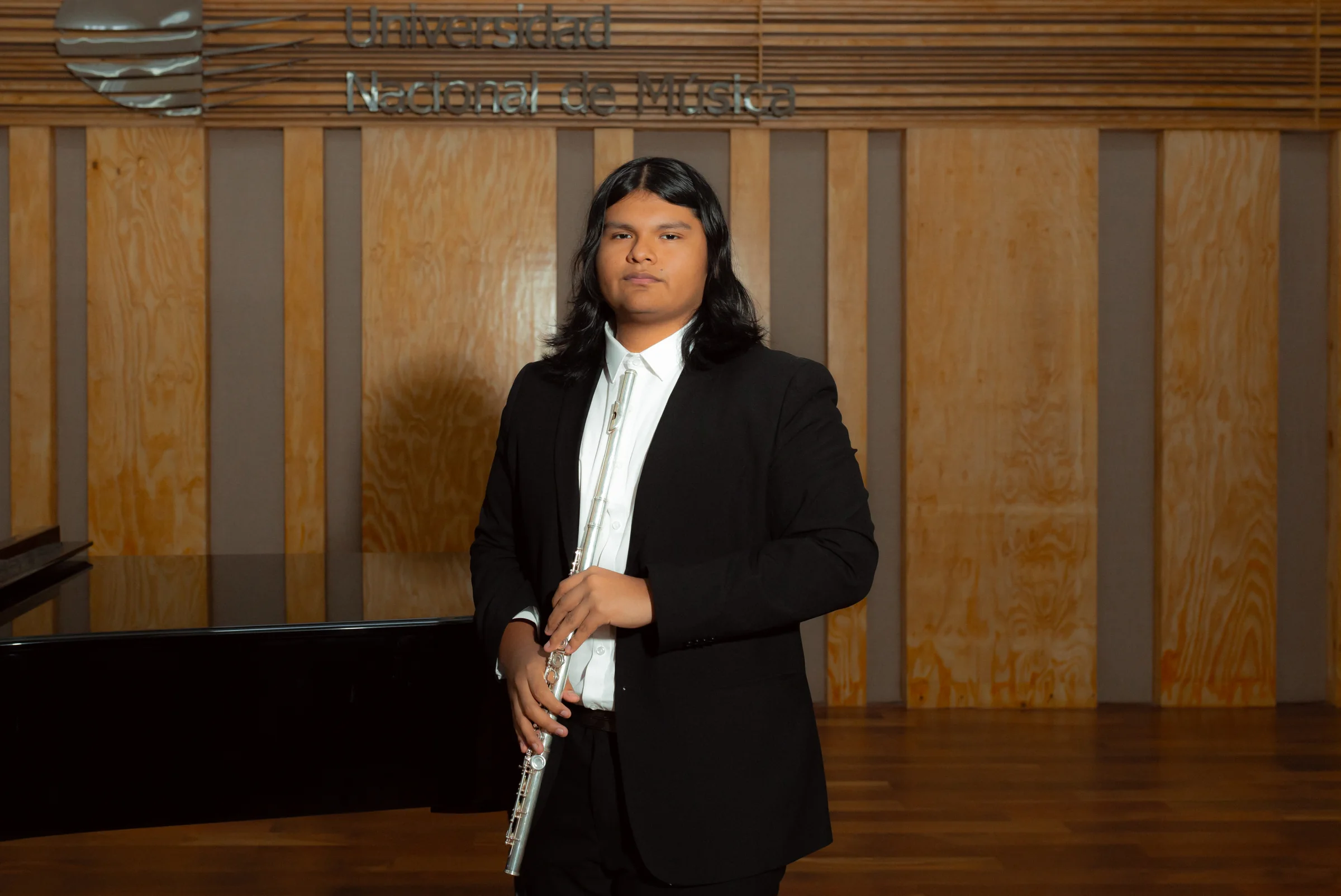 Retrato de Adrián Cruz sosteniendo su flauta
