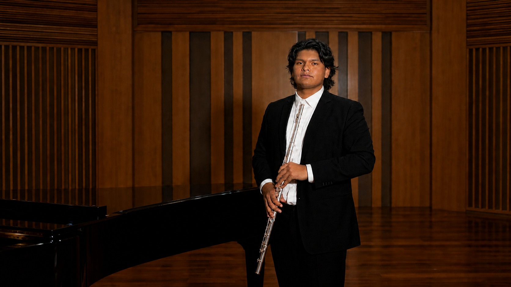 Adrián Cruz, flautista peruano, con su flauta en una sala de conciertos